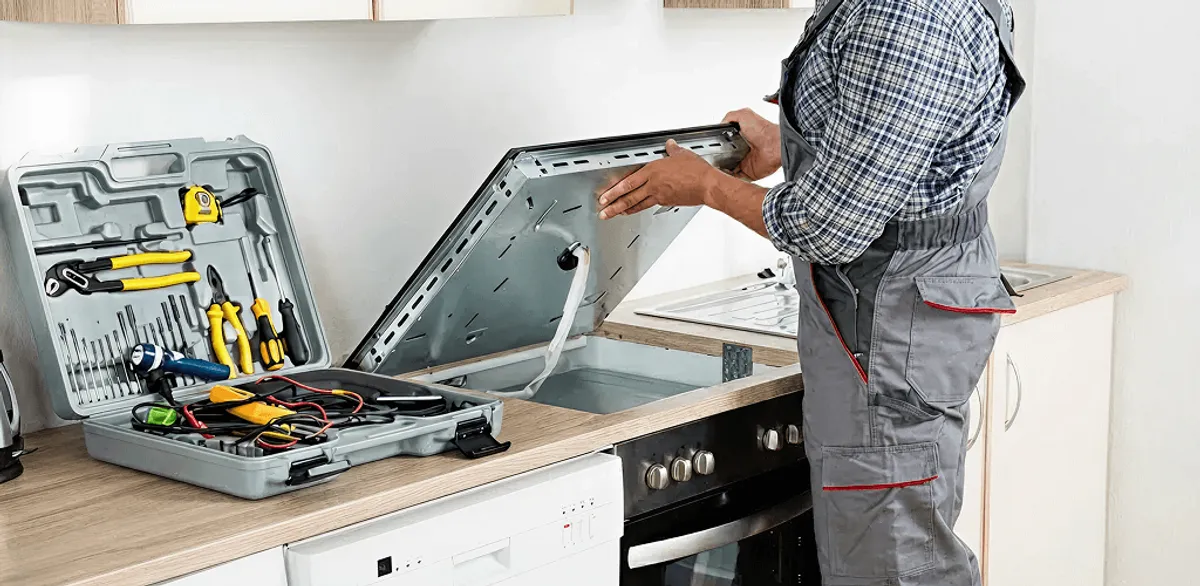 Handyman repairing a cooktop and checking wiring connections in Chicago, IL