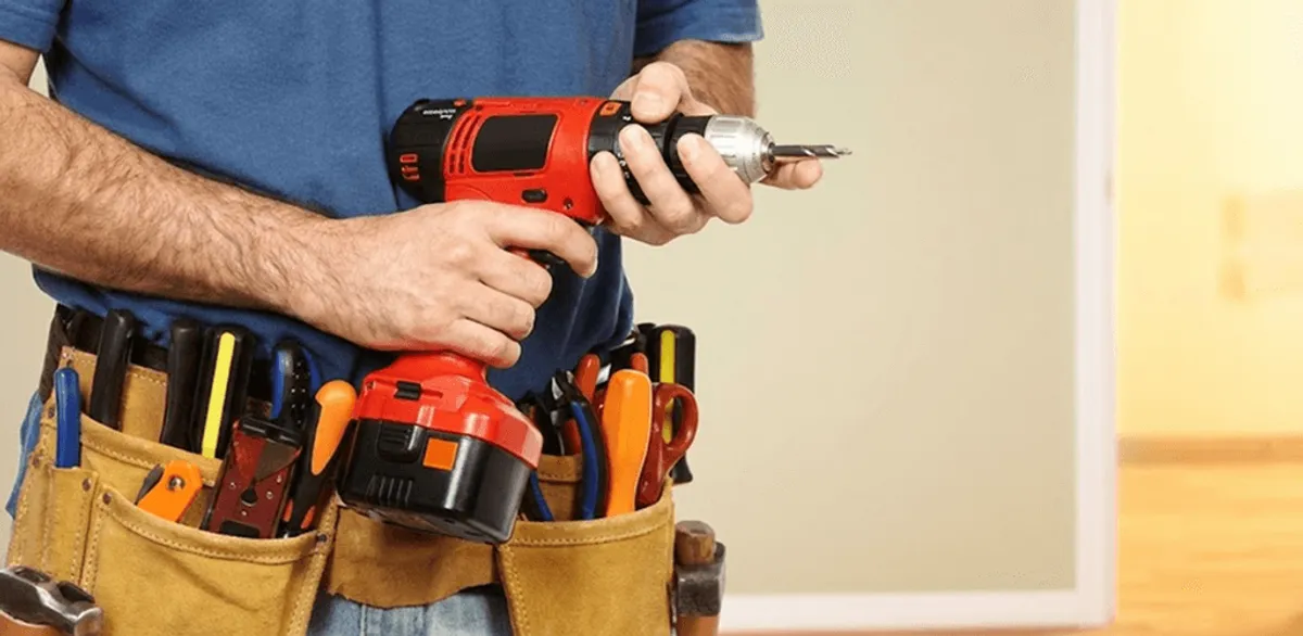 Handyman holding a power drill for home repairs and installations in Chicago, IL